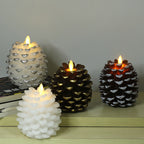 Set of four decorative candles with unique designs on a wooden surface.
