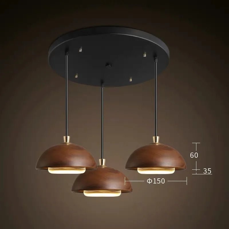 Modern pendant light fixture with three brown lampshades on a dark background