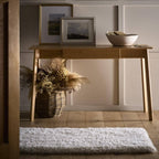 Wooden console table with decorative items against a paneled wall.