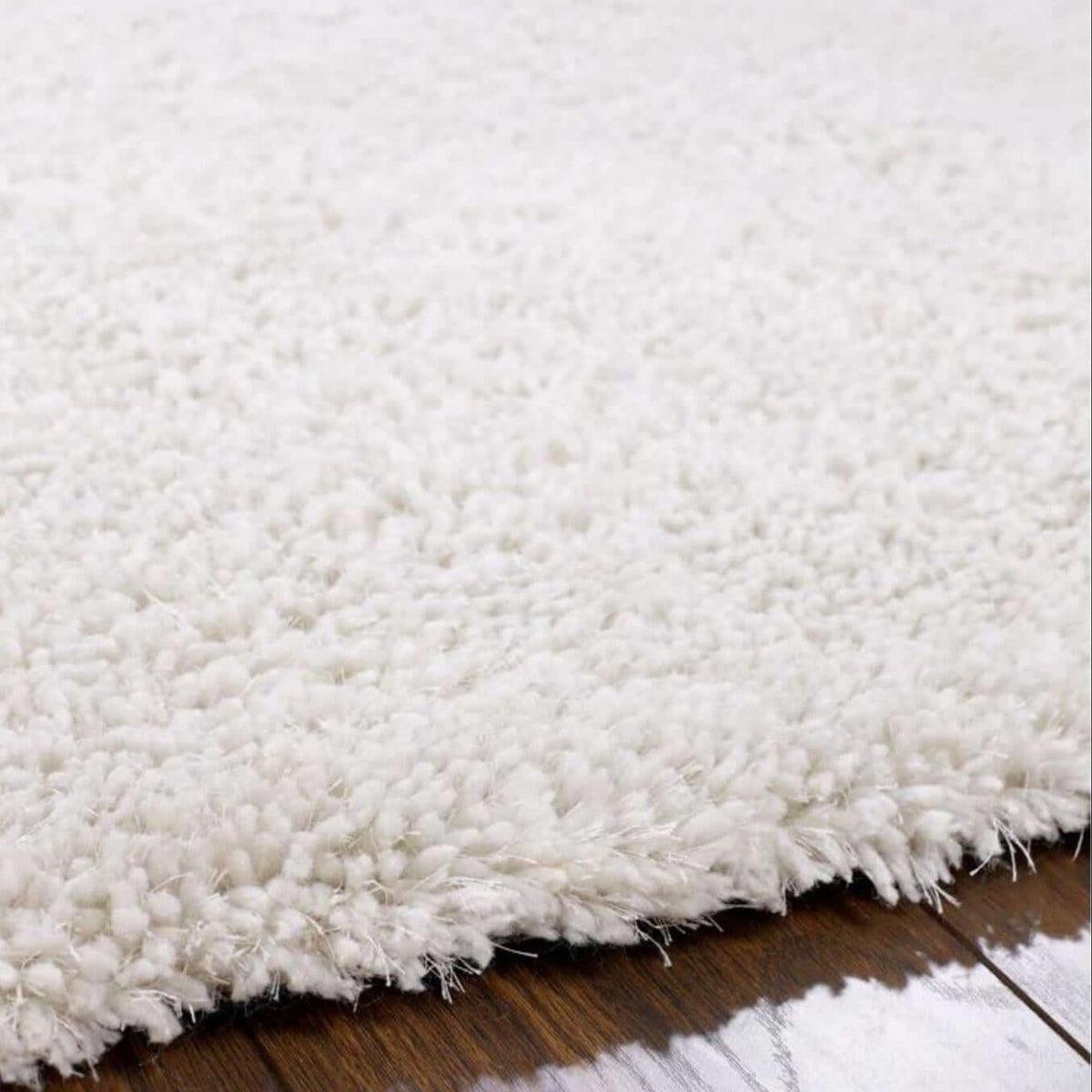Close-up of a fluffy white rug on a wooden floor