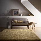 Living room with a gray sofa, yellow cushions, and a textured rug.