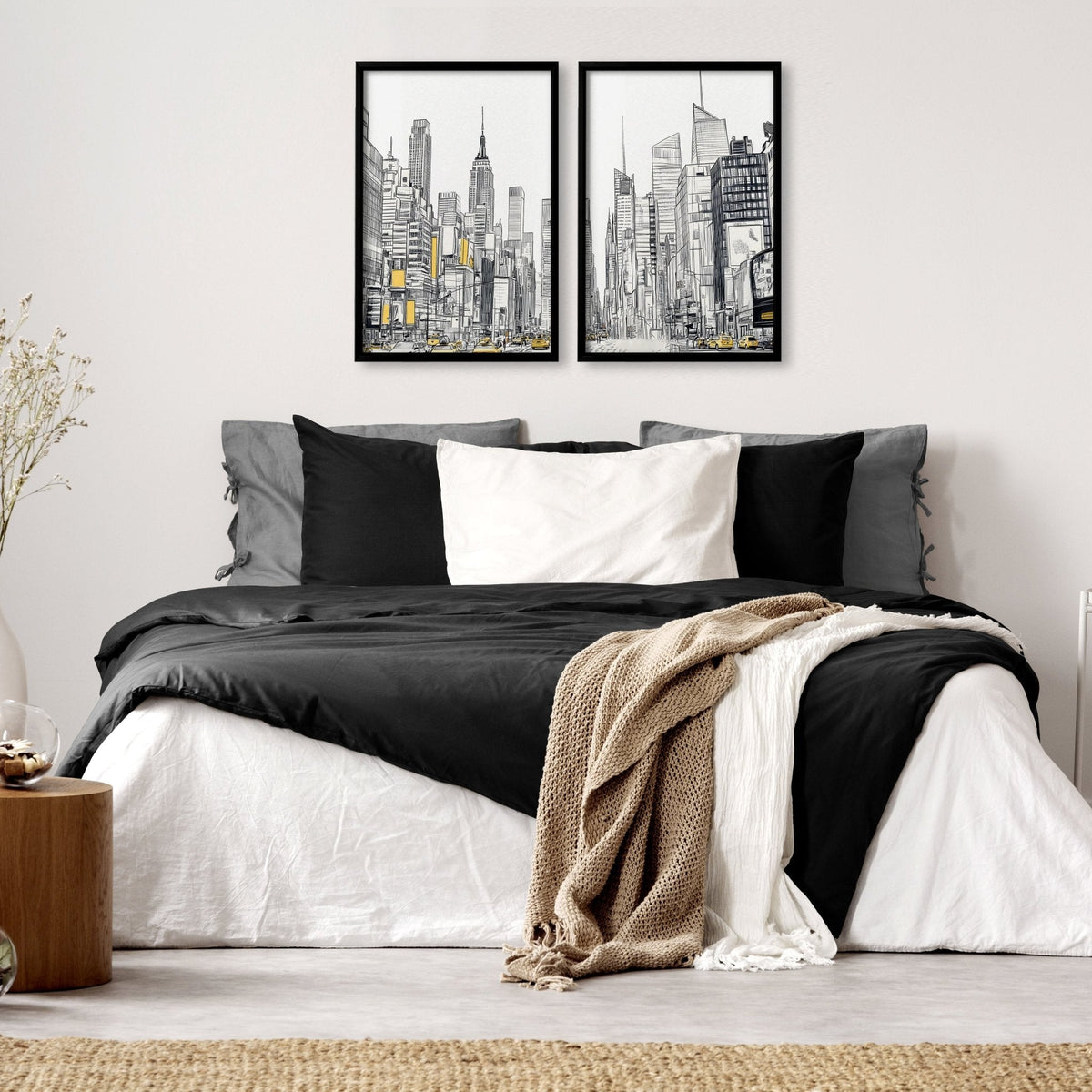 Bedroom with a bed featuring black, white, and gray bedding, two framed cityscape artworks on the wall, and a wooden side table.