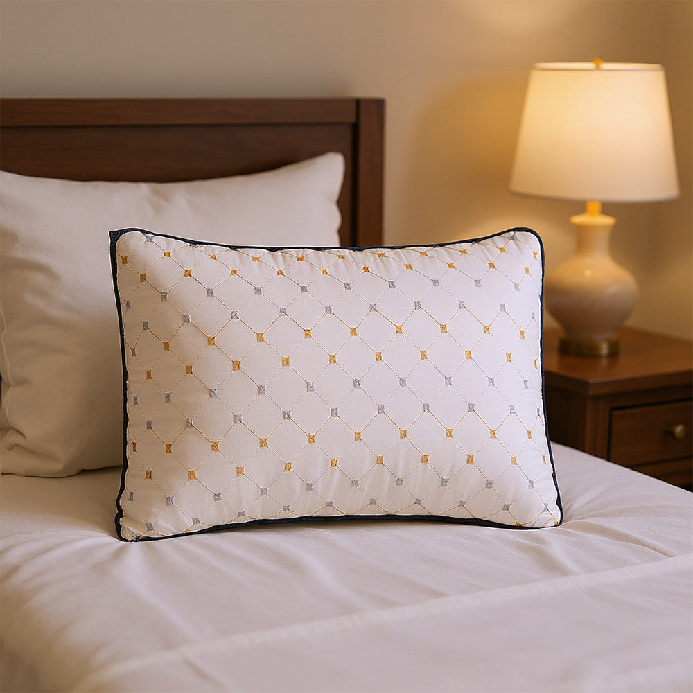Decorative pillow with geometric pattern on a bed in a bedroom setting.