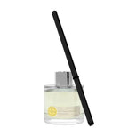 Glass diffuser bottle with black reed stick on a white background