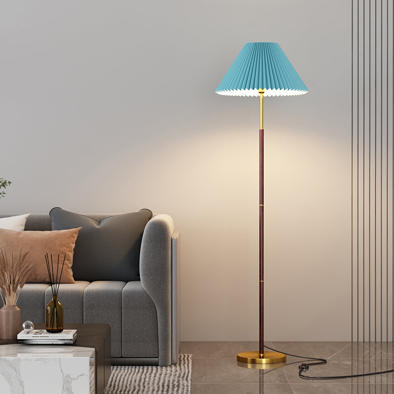 Floor lamp with pleated blue shade in a living room setting