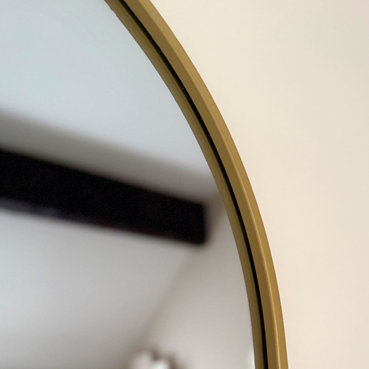 Close-up of a curved surface with a gold frame on a neutral background