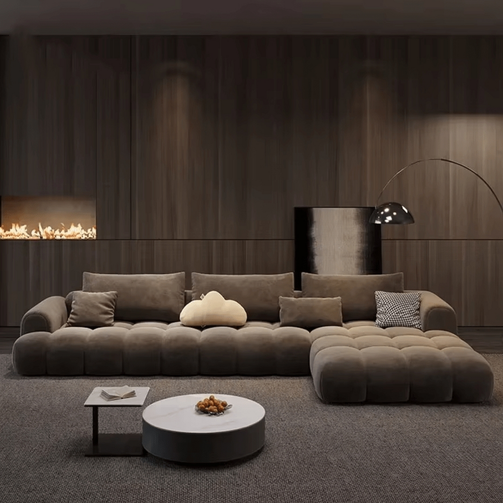 Modern living room with a large brown sofa, coffee table, and decorative items.