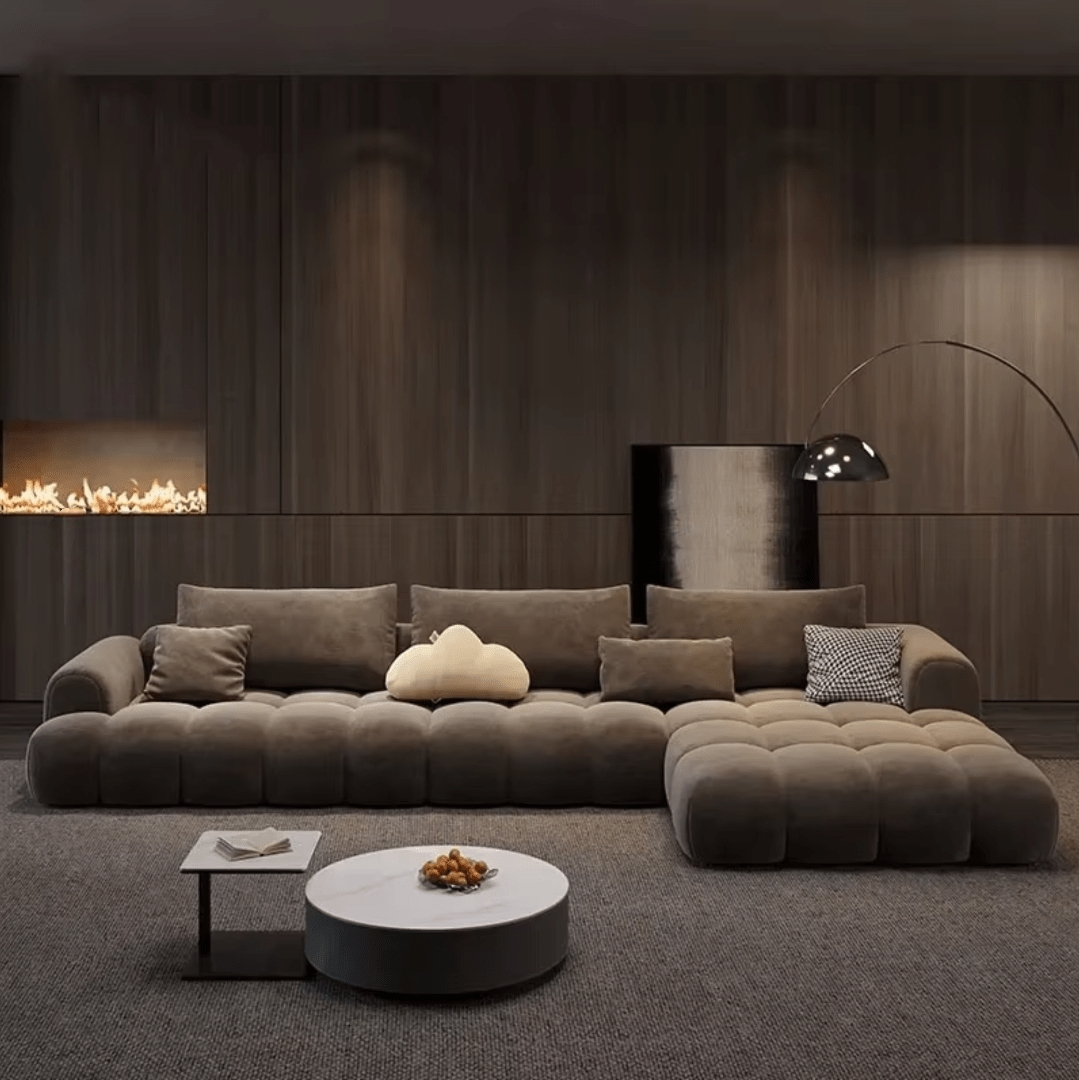 Modern living room with a large brown sofa, coffee table, and decorative items.