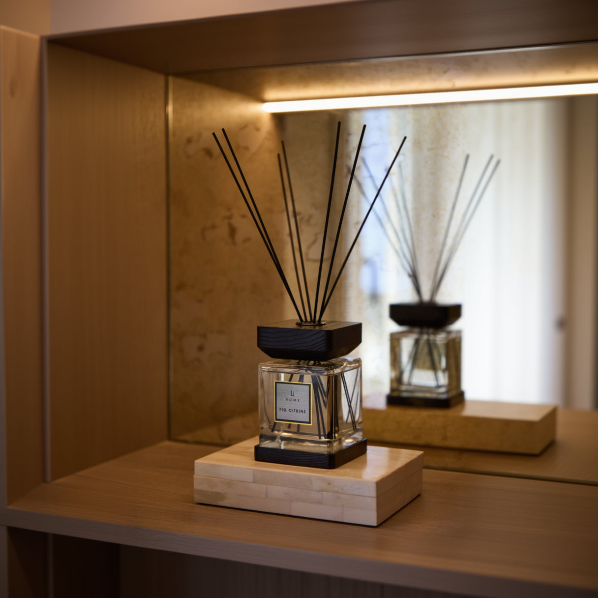 Reed diffuser on a wooden stand with a blurred background