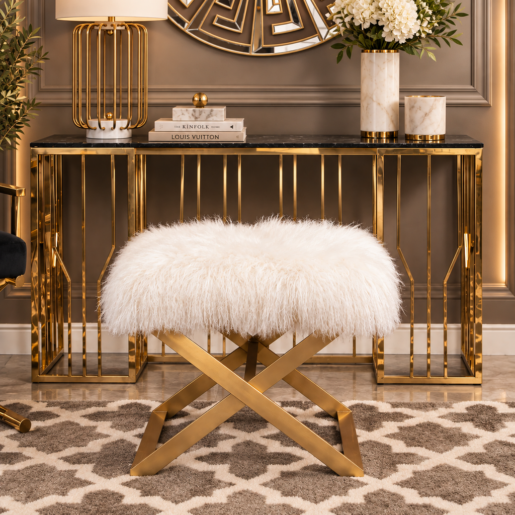 White faux fur ottoman with gold crossed legs styled in an elegant luxury interior