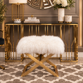 White faux fur ottoman with gold crossed legs styled in an elegant luxury interior