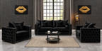 A luxury black tufted velvet living room furniture set, including a three-seater sofa, two armchairs, and a round coffee table, arranged on a beige rug in a modern styled room with dark wood-paneled walls and gold lip art prints.