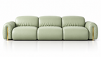A modern three-seater sofa upholstered in light sage green leather, featuring curved armrests and slim gold-toned metal legs, shown against a clean white background with a subtle reflection.