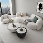Modern living room with a white sectional sofa, armchair, and coffee tables.