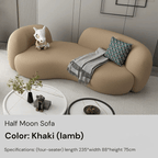 Khaki half moon sofa in a modern living room setting with a small table and decorative items.
