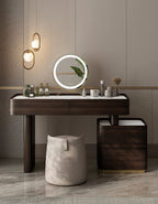 Modern vanity table with round mirror and decorative items in a bathroom setting.