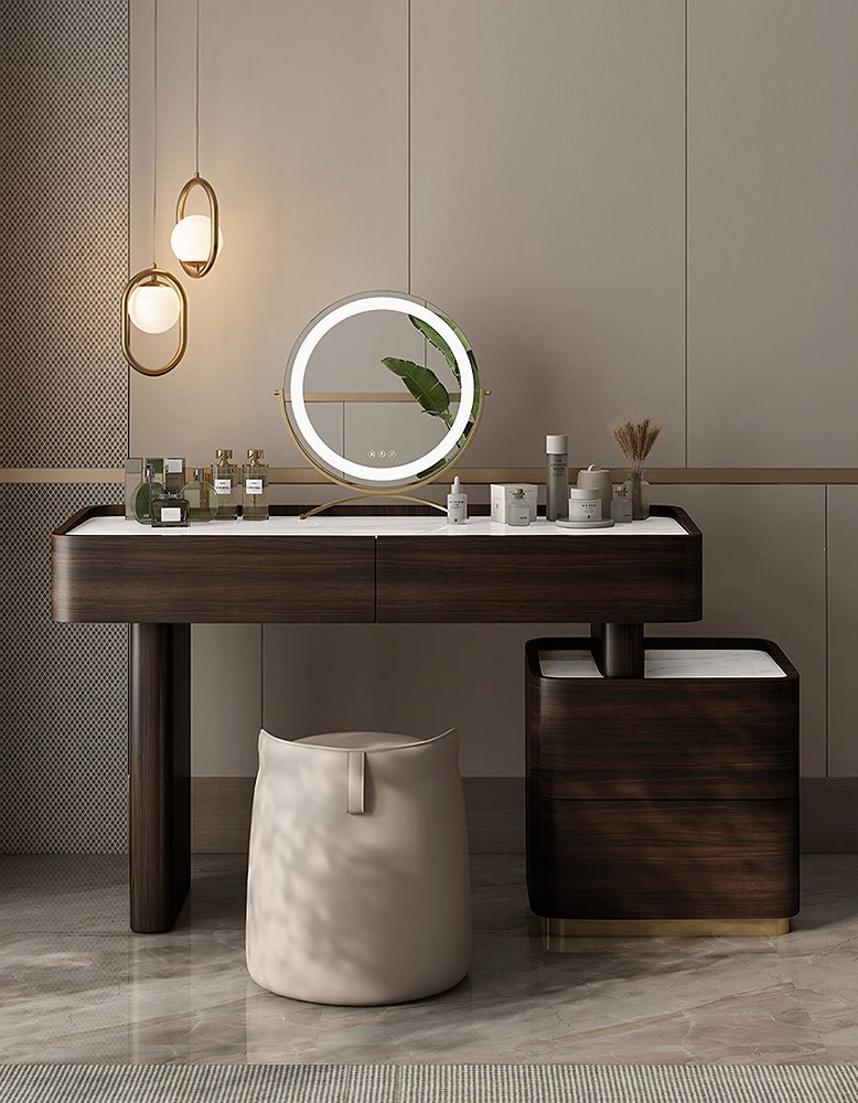 Modern vanity table with round mirror and decorative items in a bathroom setting.