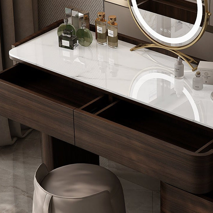 Bathroom vanity with marble countertop, mirror, and toiletries.