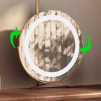 Round illuminated mirror with gold frame on a wooden surface