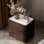 Wooden nightstand with decorative items including a vase of flowers and books.