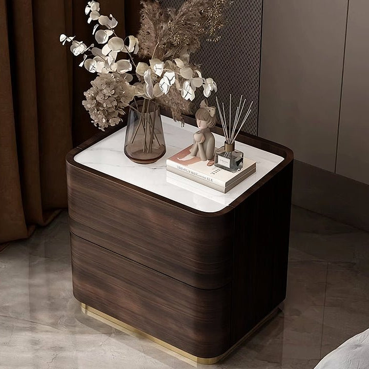 Wooden nightstand with decorative items including a vase of flowers and books.