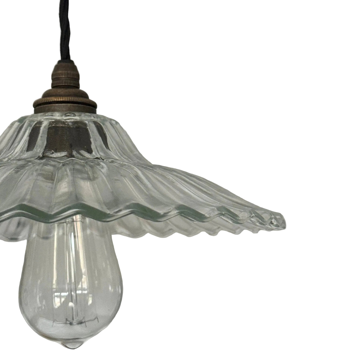Vintage-style pendant light with clear glass shade and exposed bulb against a neutral background