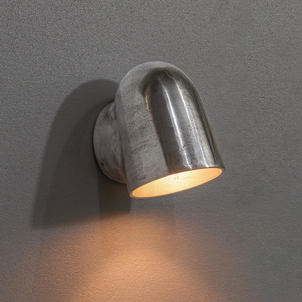 Metal wall light fixture on a gray wall