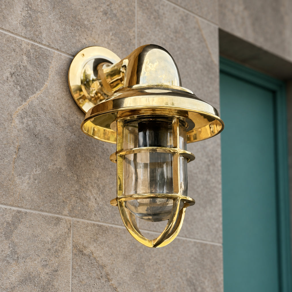 Gold outdoor wall light fixture on a concrete wall.