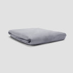 Folded gray blanket on a light gray background
