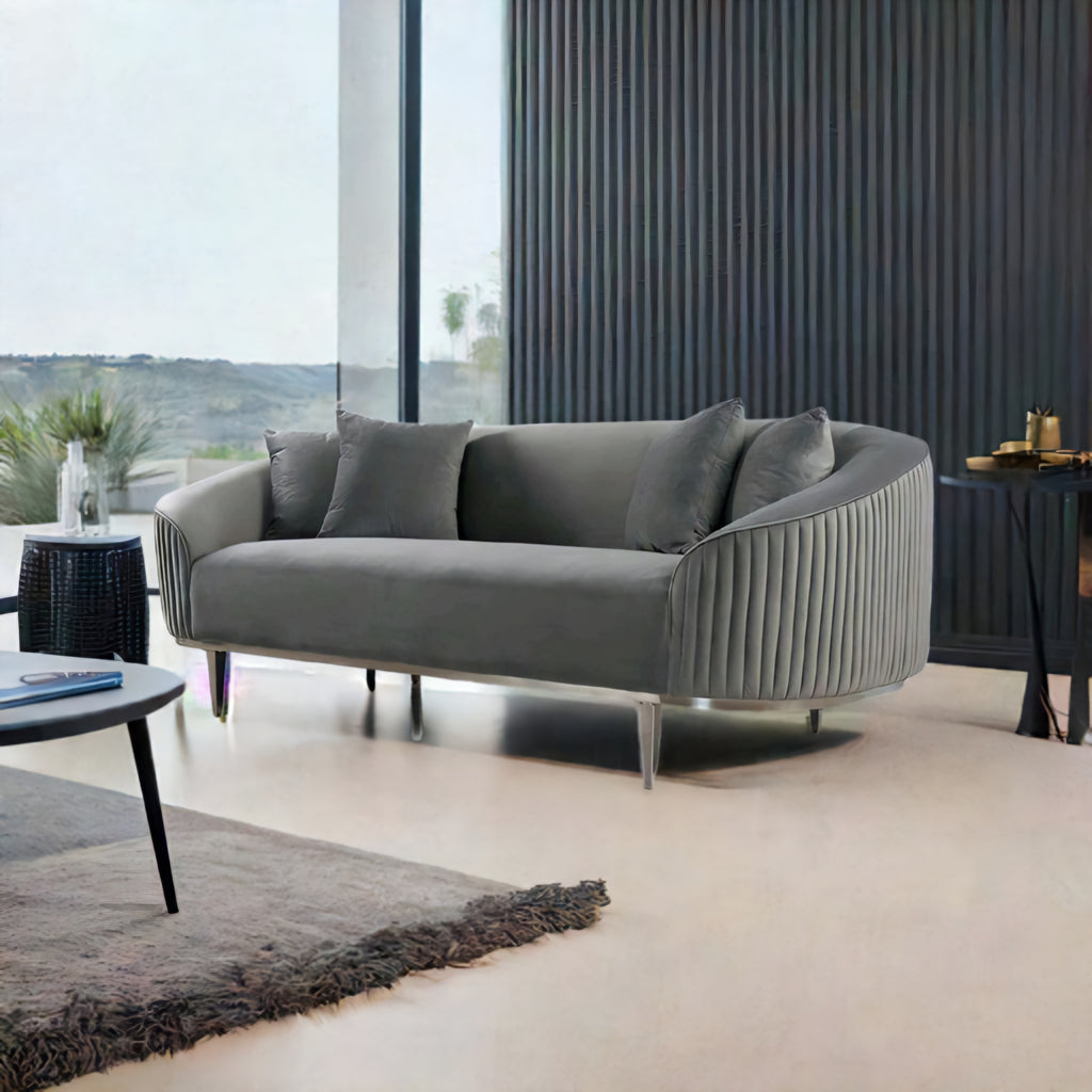 Gray sofa in a modern living room with large windows and decorative elements.