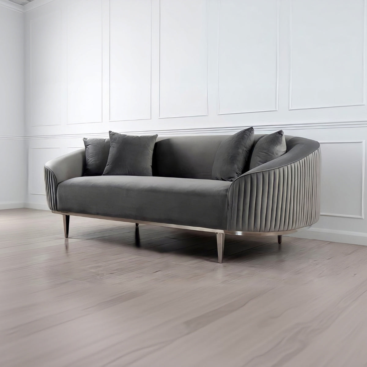 Gray sofa with decorative pillows in a room with white walls and wooden floor.