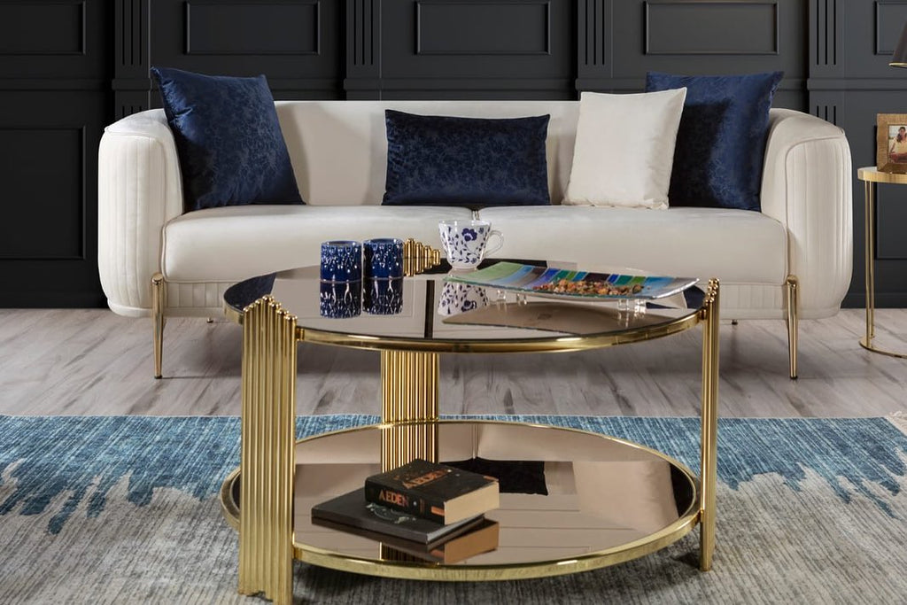 Modern living room with a white sofa, gold coffee table, and decorative items.
