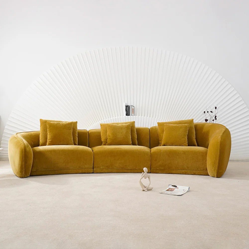 Mustard yellow sofa in a minimalistic room with a white textured wall.