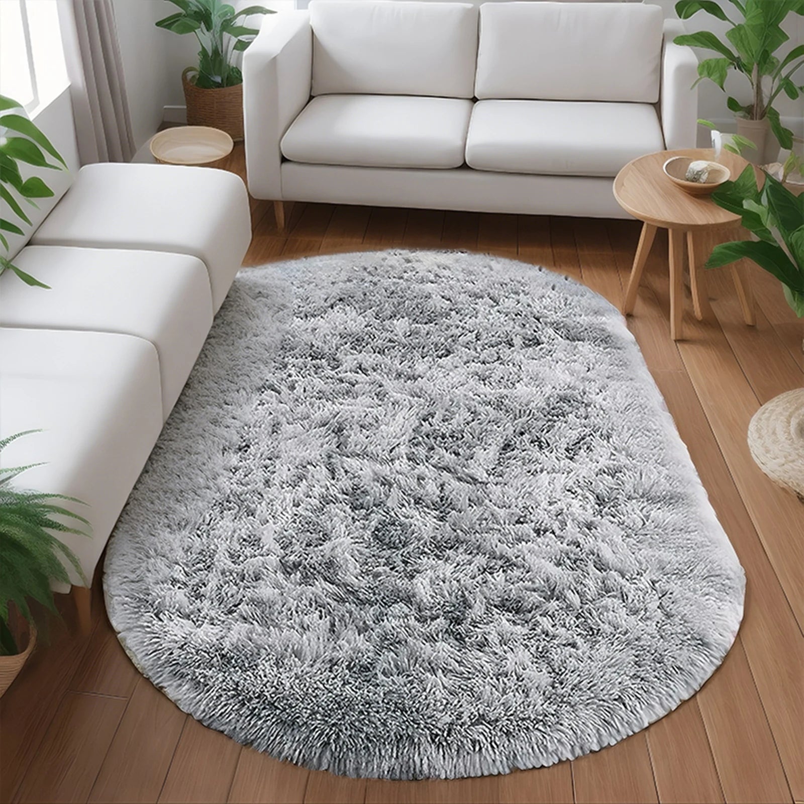 Gray shaggy rug on a wooden floor in a living room with white furniture and plants.