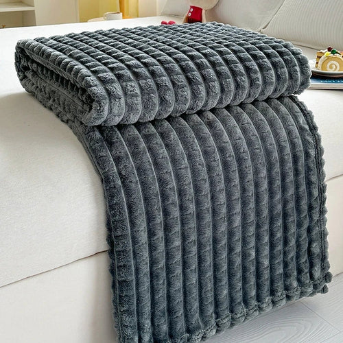 Folded gray textured blanket on a white couch