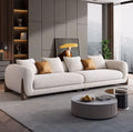 Modern living room with a beige sofa, coffee table, and decorative elements.