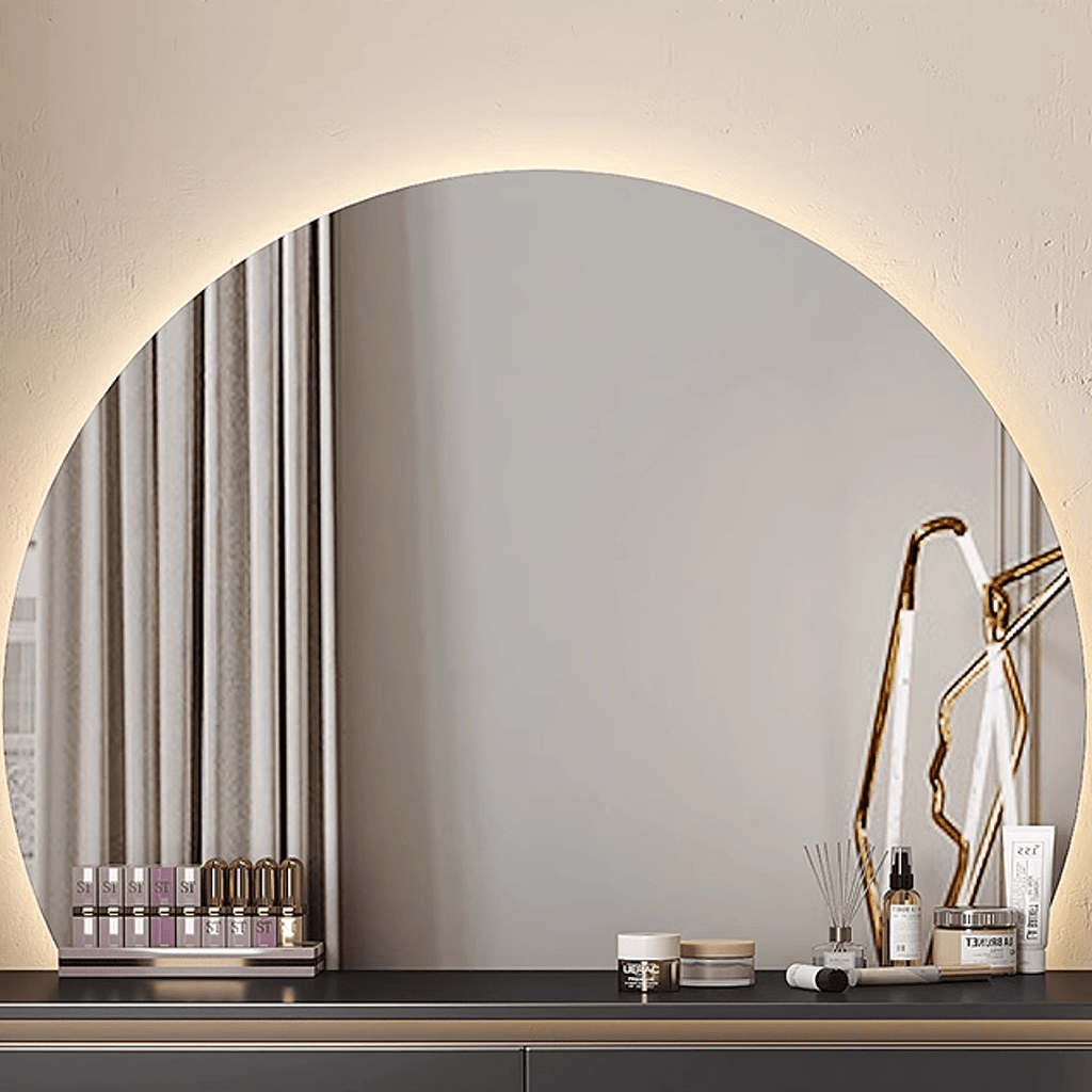 Round mirror on a wall with decorative items on a shelf below