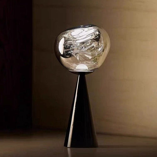 Modern table lamp with a unique design on a dark surface.