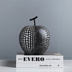 Black and white patterned apple sculpture on a book with 'EVERO' branding.