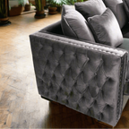 Gray tufted armchair with cushions on a wooden floor