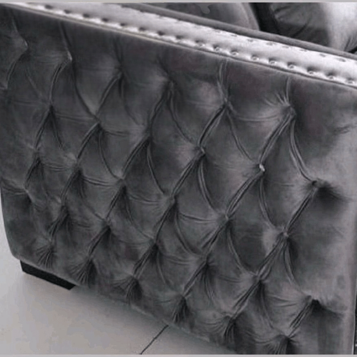 Gray tufted velvet armchair on a light gray floor.