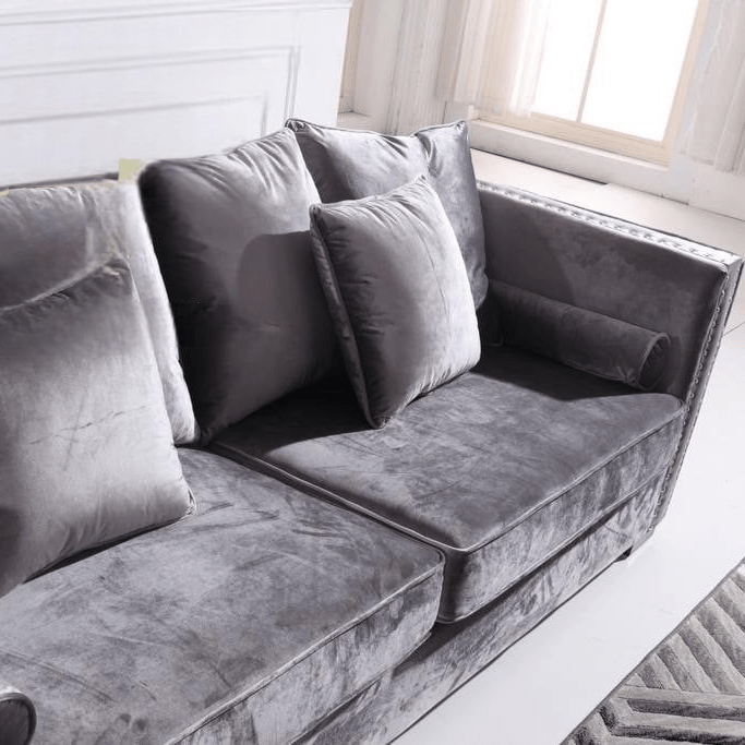 Gray velvet sofa with cushions in a bright room