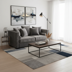 Modern living room with a gray sofa, coffee table, and abstract art on the wall.