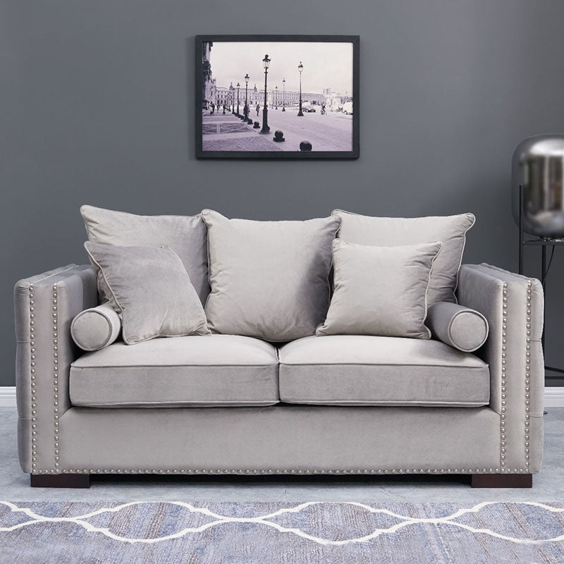 Gray sofa with decorative pillows in a room with a framed picture on the wall.