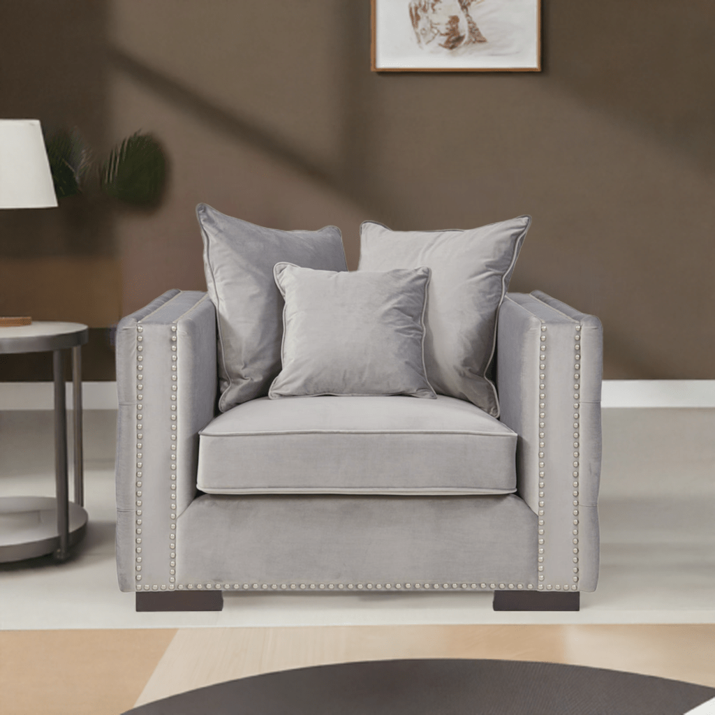 Gray armchair with decorative pillows in a living room setting.