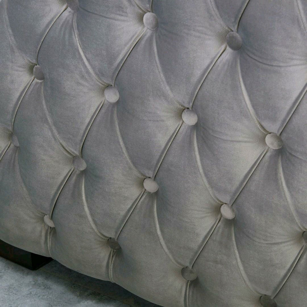 Close-up of a tufted gray upholstered headboard