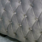 Close-up of a tufted gray upholstered headboard