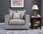 Gray armchair with decorative pillows in a living room setting.
