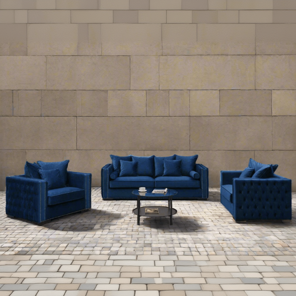 Blue sofa set with matching armchairs on a stone patio against a brick wall.
