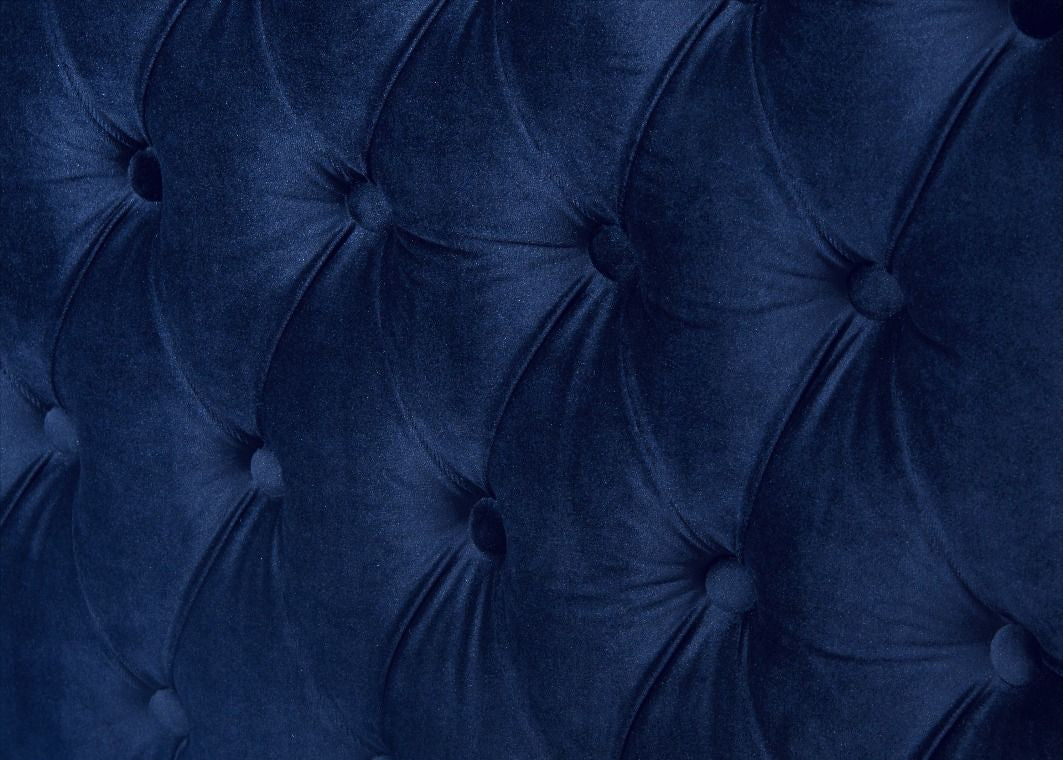 Close-up of a tufted blue velvet headboard
